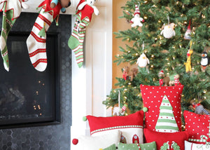 festive green, red, and white christmas decor inlcuding 3 stockings, pile of pillow cushions, and multiple holiday animal ornaments.